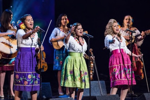 image of Mariachi Las Colibri on stage singing in colorful dress